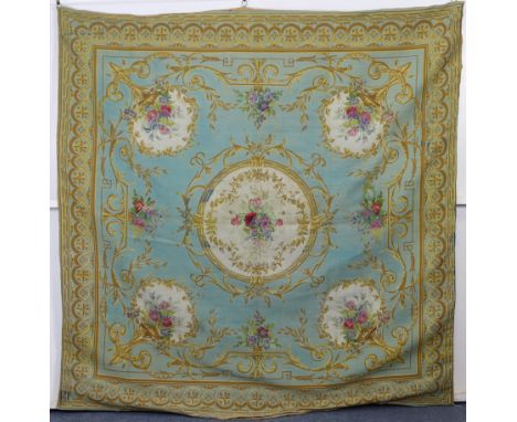 A 20th century French tapestry in the Aubusson style, of light blue ground with cream reserves of flowers in gold scrolling b