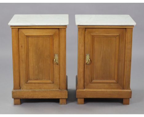 A pair of late 19th/early 20th century Continental fruitwood bedside cupboards, en-suite, each with white marble top above a 