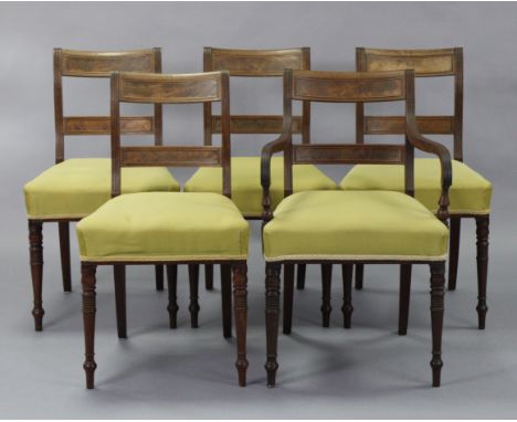 A set of five regency mahogany dining chairs, including one carver, with figured panels to the open reeded backs, on ring-tur