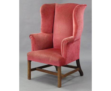 A beech-frame Georgian-style wing-back armchair, upholstered light red velour, on square legs with “H” stretcher. (one back l