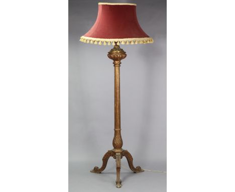 A carved giltwood standard lamp, with gilt metal baluster-shaped terminal above a carved &amp; fluted column on three cabriol