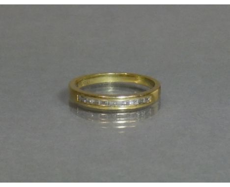 An 18ct gold half-hoop ring set row of ten small baguettes; size N, weight 2.7g.