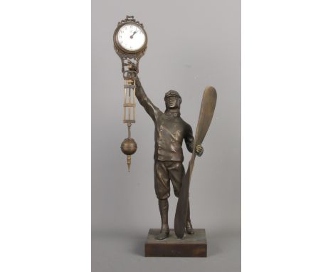 A decorative bronze aviator themed swinging clock, with Arabic numerals and "J" symbol on dial, possibly made by Junghans Ger