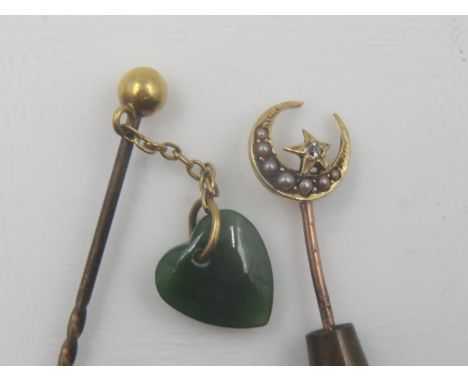 Two unmarked yellow metal stick pins, one with crescent and star set with white stone and seed pearls, the other with small g