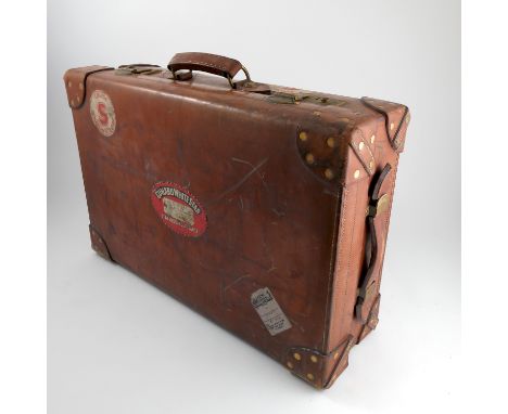 A Vintage brown leather suitcase, the interior lined in Moroccan red tooled leather, bearing labels for Cunard White Star Lin