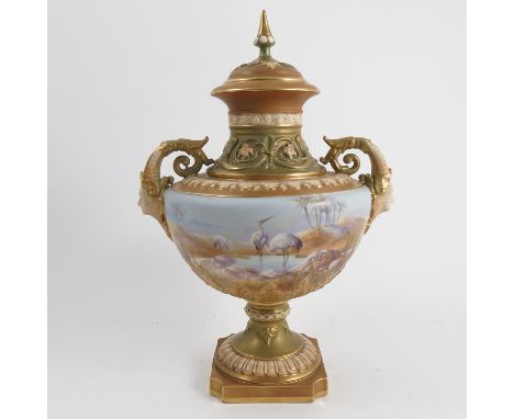 A Royal Worcester covered vase, decorated with storks wading in a desert landscape on a powder blue ground by W Powell, with 