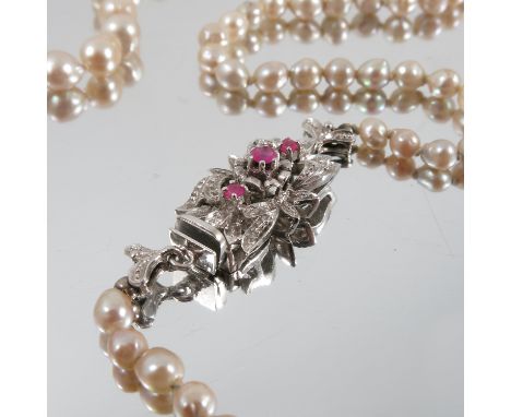 A graduated row of baroque cultured pearls, the eighty pearls of approximately 3.5mm-6mm, 49cm long, to a ruby set clasp stam
