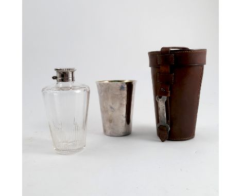 A leather case, containing a silver beaker with gilt wash interior and a silver mounted and glass flask, having a hinged cove