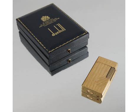 A boxed gold plated Dunhill lighter, with textured surface, with instructions