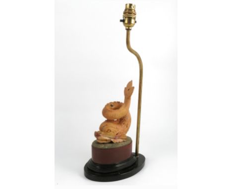 A table lamp, with a carved marble dolphin, raised on an oval base, height 10ins