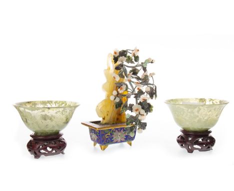 TWO CHINESE JADE TEA BOWLS, in mottled green, on wooden stands, each 10cm diameter; along with a hardstone tree (3)