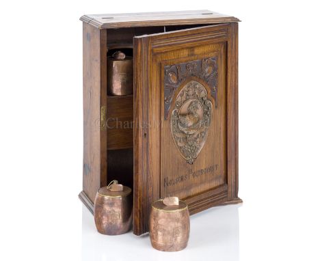 A SMOKER’S CABINET MADE FROM FOUDROYANT OAK BY GOODALL, LAMB &amp; HEIGHWAY, CIRCA 1898 the door with copper plaque of the wr