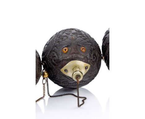 A 19TH CENTURY CARVED COCONUT BUGBEAR carved in the round with ?conquistadores boar hunting, sporting couples, the face with 