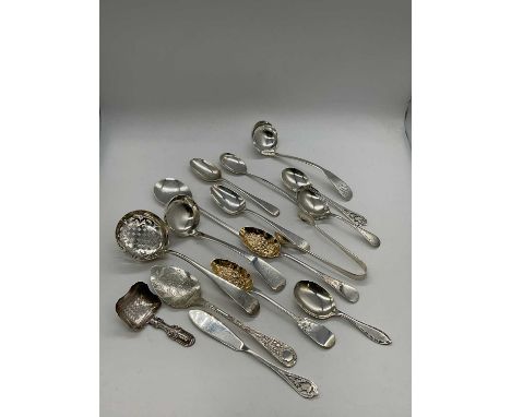 A group of hallmarked silver flatware comprising two sauce ladles, a sifting spoon, pair of sugar tongs, three caddy spoons, 