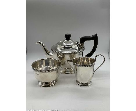 EDWARD VINER; a George VI hallmarked silver three piece tea set with band of detail to each piece, the teapot with ebonised h