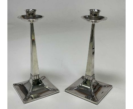 JAMES DIXON &amp; SONS; a pair of Edwardian hallmarked silver Arts and Crafts candlesticks, the design attributed to Jan Eise