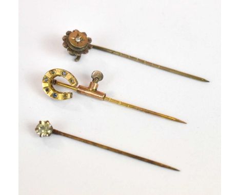 Three yellow metal stick pins contained within a velvet lined leather box, combined 3.22g.