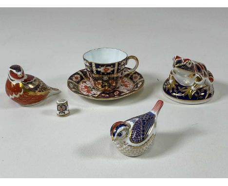 ROYAL CROWN DERBY; three paperweights (both birds with gold stoppers, frog with no stopper), a thimble and a cup and saucer (