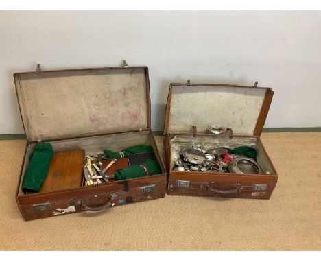 Two vintage leather suitcases containing silver plated items, including teapot, twin handled bowl, and a large quantity of fl