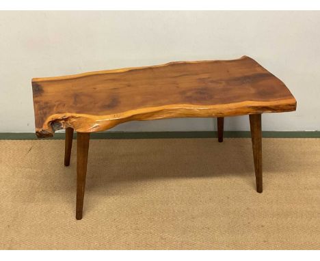 A late 20th century coffee table constructed from a section of a tree trunk on four raised supports, height 41cm, width 89cm,