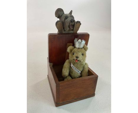 ATTRIBUTED TO SCHUCO; a small teddy bear wearing a Berlin sash, crown, and with tongue sticking out, length 13cm, also a nove