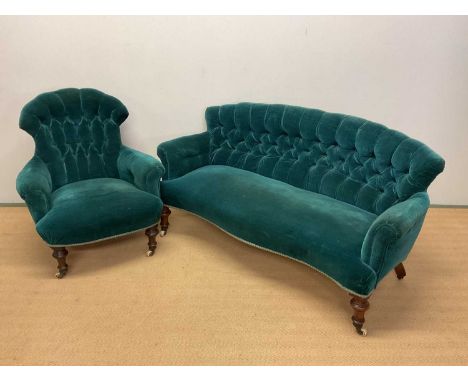 A Victorian walnut framed button upholstered salon settee raised on ring turned front legs to brass caps and castors with mat