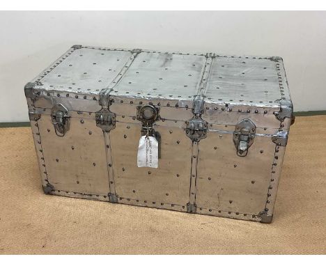 Aluminium travelling trunk with rivet detailing, height 53cm, width 102cm, depth 53cm.