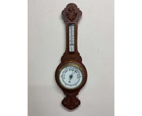 A carved oak barometer with porcelain dial and scale, length 71cm.