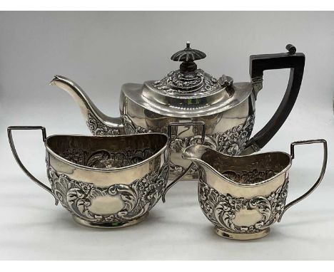 An Edwardian hallmarked silver and foliate embossed three piece tea set, Birmingham 1902, length of teapot 23.5cm, combined a