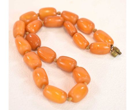 A vintage hand tied egg yolk/butterscotch amber bead necklace formed of twenty beads, length 43cm, each approx 18.5 x 12.5mm,