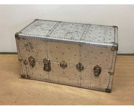 Aluminium travelling trunk with rivet detailing, height 56cm, width 102cm, depth 54cm.
