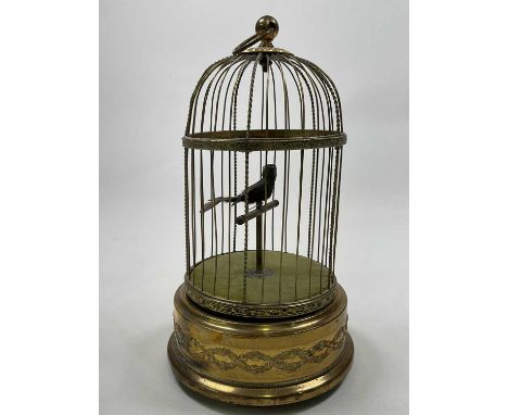 An early 20th century singing automaton single bird birdcage with scroll detail to the cylindrical base, height 30cm, working