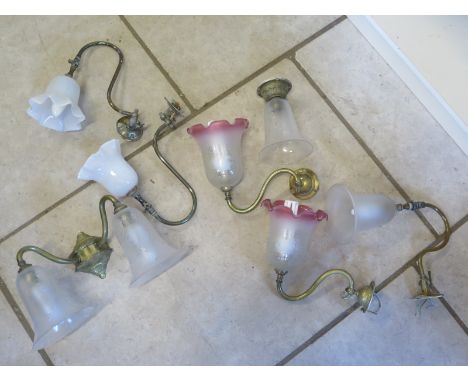 Six vintage wall lamps and a double headed wall lamp, all with glass shades, brass fittings, three with original gas switches