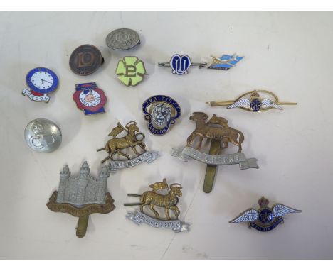 Four British army regimental badges and an RAF tie pin and enamel badge, three pin cap badges for the Queens Regiment one for