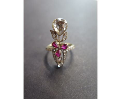 An early 20th Century gold ruby and diamond dress ring, of foliate design the principal pear-shape rose cut diamond to the pe