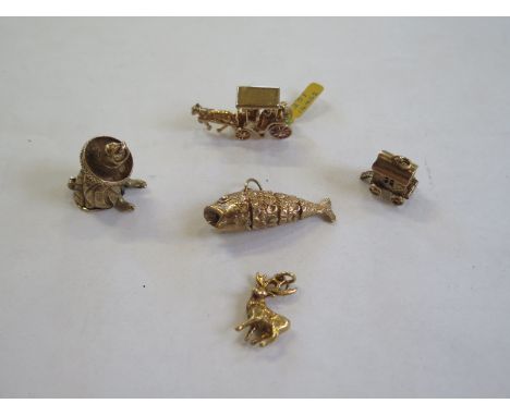 Five 9ct gold charms, including an articulated fish, a Mexican with a hidden guitar, two carriages and a stag - approx 31 gra