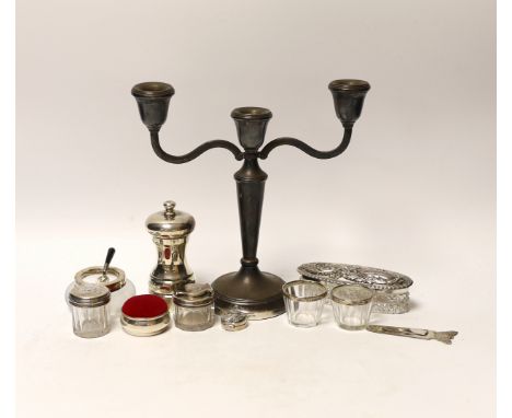 A group of mixed silver including a modern candelabrum, toilet jars and a pepper grinder.