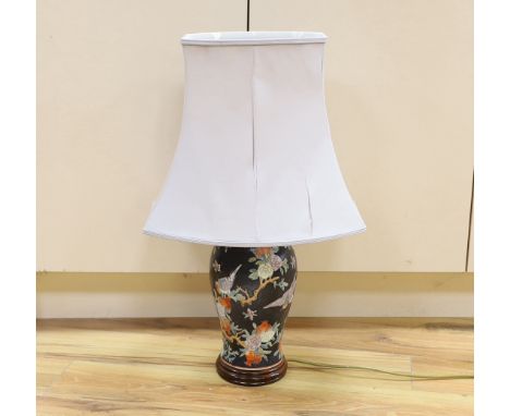 A Chinese famille noire table lamp and a pink ground Chinese vase, both on wooden stands, tallest vase 39cm