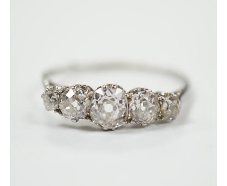 An 18ct white metal and graduated five stone diamond set half hoop ring, size X/Y, gross weight 2.2 grams.