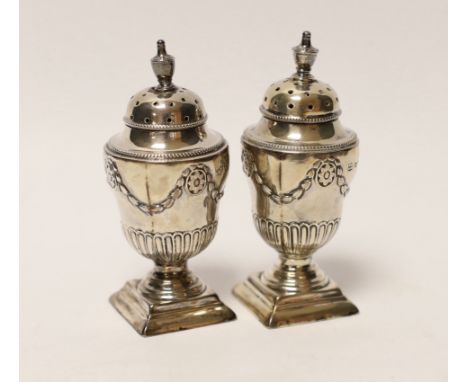 A pair of Victorian silver urn shaped pedestal pepperettes, Henry Wilkinson &amp; Co Ltd, Sheffield, 1880, 83mm.