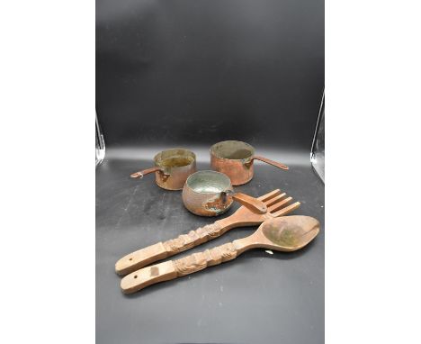 Three vintage hammered copper saucepans and a large carved Eastern fork and spoon. L.57cm 