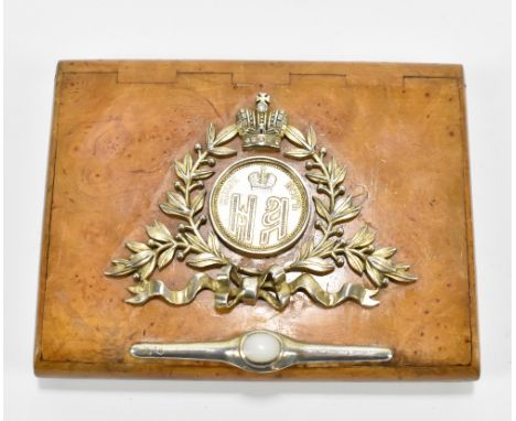 A Russian birch cigarette case with applied silver decoration depicting a crown above foliate, ribbon and panel with white st