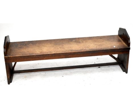 An early 20th century stained pine bench in the Gothic style.