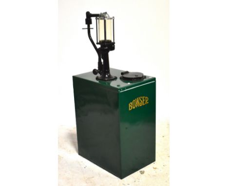 A metal green painted bowser pump.