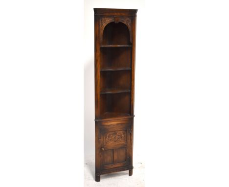 An oak corner cabinet with three shelves above cupboard door enclosing single shelf, approx 176 x 44cm.