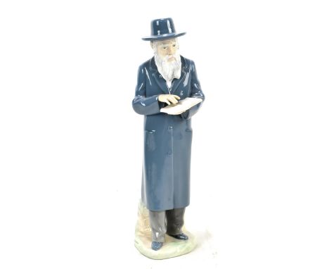 NAO; a ceramic figure of a gentleman wearing a trench coat and holding a book, with impressed marks to base, height 31cm.