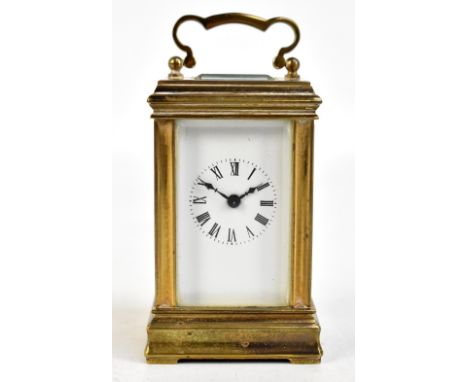 A circa 1900 miniature brass carriage clock, the white enamel dial set with Roman numerals and the back plate stamped 'ACG' a