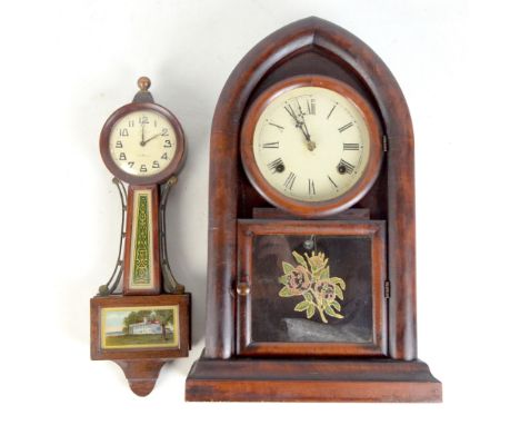 An early 20th century American mantel clock of arched form, the circular dial set with Roman numerals above a glass panel, he