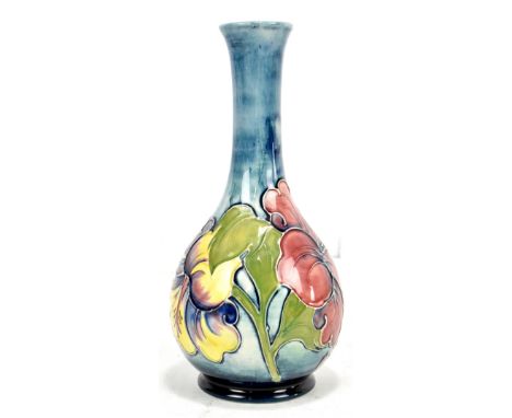 MOORCROFT; a bottle shaped vase, decorated in the 'Hibiscus' pattern on a blue ground, original label and blue signature to b