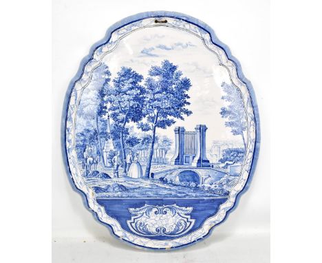A 20th century Delft wall plaque depicting figures in a landscape scene, 60 x 49cm (chipping to glaze).Additional Information